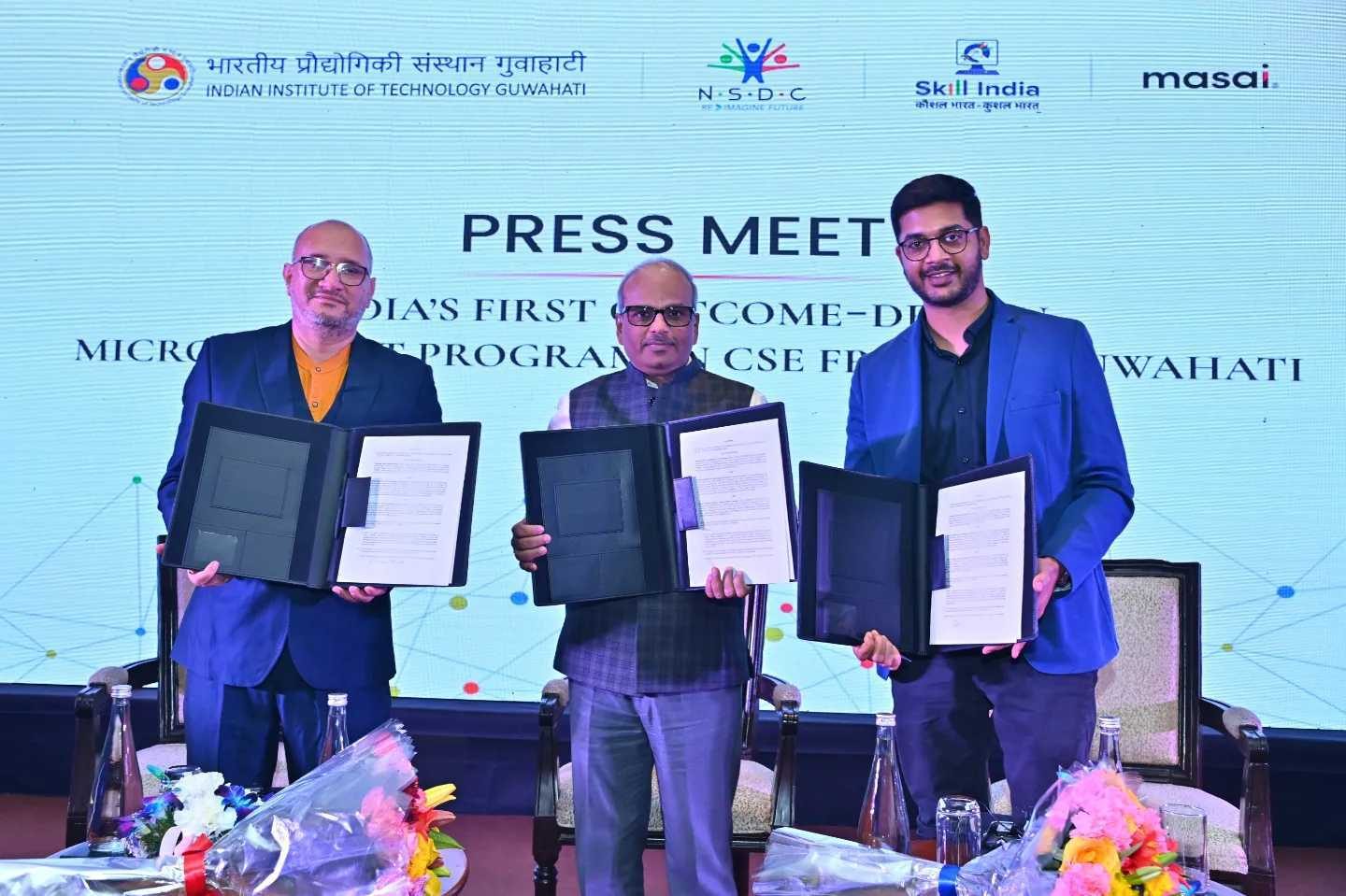 Three leaders holding signed agreements at a press meet with IIT Guwahati, NSDC and Masai