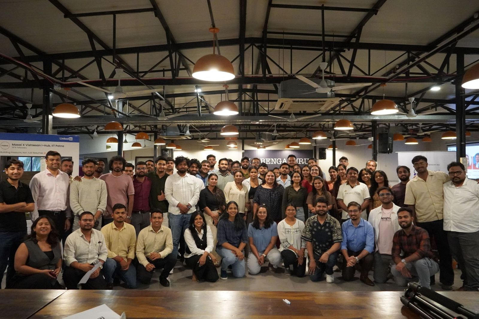 A large group of learners and mentors in an industrial-style hall
